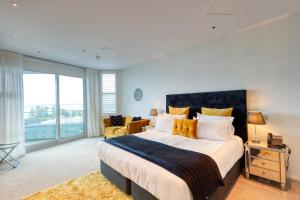 a bedroom with a large bed with a large window at Marsden Suites Nautilus Orewa in Orewa