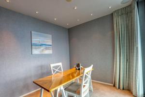 a dining room with a wooden table and chairs at Marsden Suites Nautilus Orewa in Orewa