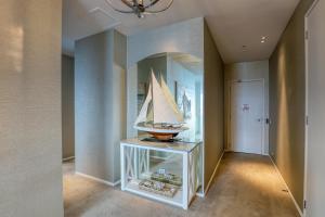 a room with a shelf with a model sailboat on it at Marsden Suites Nautilus Orewa in Orewa