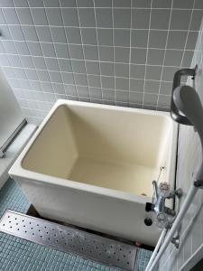a bath tub in a bathroom with a sink at Enmanin Sanmitsuden - Vacation STAY 03295v in Otsu