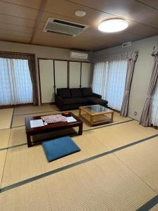 a living room with a couch and a table at Enmanin Sanmitsuden - Vacation STAY 03295v in Otsu