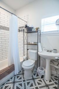 a bathroom with a white toilet and a sink at Casa Cima in Dallas