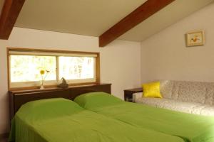 a bedroom with a green bed and a window at Suite Villa Kawaguchiko Mt Fuji House in Narusawa