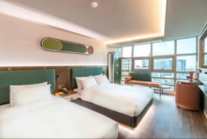 済州市にあるSH Amber Central Stayのベッド2台とソファが備わるホテルルームです。