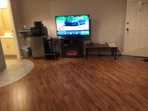 a living room with a flat screen tv and a fireplace at Parkway Motel & European Lodges in Pincher Creek