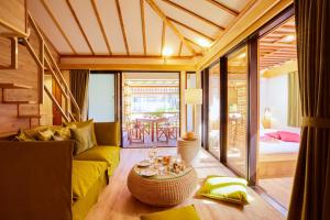 een woonkamer met een gele bank en een tafel bij Allamanda Imgya Coral Village in Miyako Island