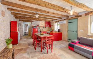 a kitchen with red cabinets and a table and chairs at Gorgeous Apartment In Zminj With Wifi in Žminj