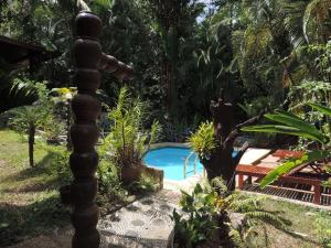 a pole in a garden with a swimming pool at Khao Sok Las Orquideas Resort in Khao Sok