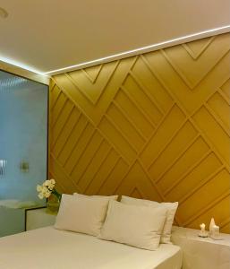sypialnia z drewnianym zagłówkiem i łóżkiem z białymi poduszkami w obiekcie Yolo Motel w mieście Brasília