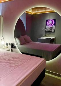 um quarto com 2 camas e um quarto redondo com paredes roxas em Yolo Motel em Brasília