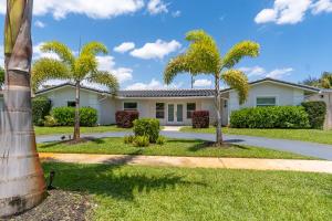 a house with palm trees in front of it at Hollywood Paradise Luxury 4BR 3BA Home and Outdoor Fun with Heated Pool in Hollywood