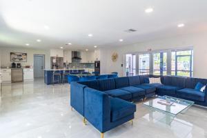 a living room with blue couches and a kitchen at Hollywood Paradise Luxury 4BR 3BA Home and Outdoor Fun with Heated Pool in Hollywood