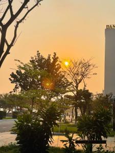 una puesta de sol en una ciudad con árboles y un edificio en Motel Tuan Phuong, en Da Nang