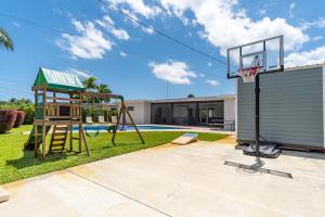 un aro de baloncesto en un patio trasero con una casa en Hollywood Paradise Luxury 4BR 3BA Home and Outdoor Fun with Heated Pool en Hollywood