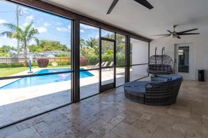 uma sala de estar com uma piscina e uma ventoinha de tecto em Hollywood Paradise Luxury 4BR 3BA Home and Outdoor Fun with Heated Pool em Hollywood