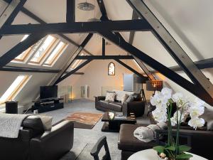 a living room with couches and tables in a attic at Converted chapel - Sant Pedr Newydd - with sea views in Amlwch