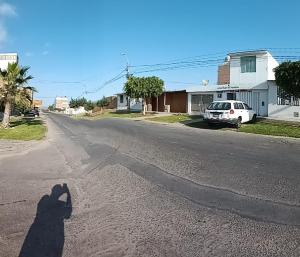 una sombra de una persona tomando una foto de una calle en Starfish of Paracas, en Paracas