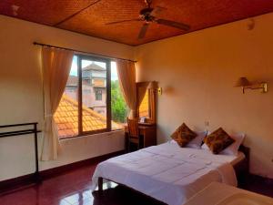 ein Schlafzimmer mit einem Bett und einem großen Fenster in der Unterkunft Candra Asri Bungalow in Ubud