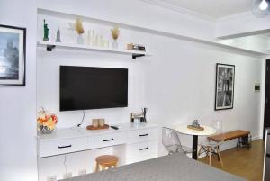 sala de estar con TV en una pared blanca en New York Suite III at Avida Towers Aspira, en Cagayan de Oro
