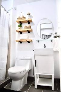 Baño blanco con aseo y espejo en New York Suite III at Avida Towers Aspira, en Cagayan de Oro