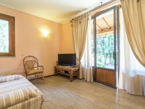 1 dormitorio con 1 cama, TV y ventana en Stunning holiday home in Arezzo with private garden, en Arezzo