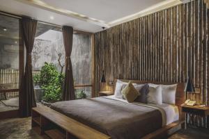 a bedroom with a bed with a wooden wall at The Tiing Tejakula Villas in Tejakula