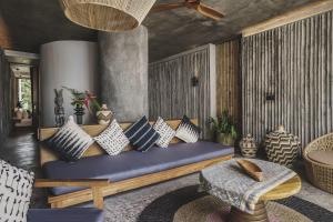 sala de estar con sofá azul y almohadas en The Tiing Tejakula Villas, en Tejakula