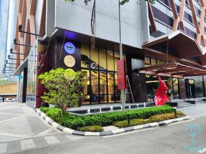 un edificio con una mujer en un vestido rojo delante de él en Scarletz Suites KLCC by Mykey Global en Kuala Lumpur