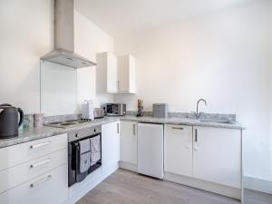 a white kitchen with white cabinets and a sink at Two - Uk43700 in Saint Annes on the Sea