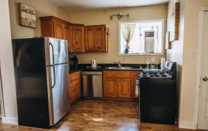 una cocina con nevera de acero inoxidable y armarios de madera en Dreamers Writing Farm, 3 Wooded Acres, Hepworth, en Sauble Beach