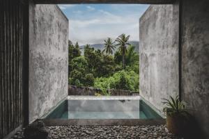 a view of a swimming pool from the inside of a house at The Tiing Tejakula Villas in Tejakula