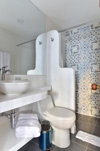 a white bathroom with a toilet and a sink at Aldea Bella Boutique in Doradal