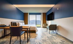 une chambre d'hôtel avec un lit, une table et des chaises dans l'établissement Anseong Nomad Hotel, à Anseong