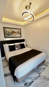a bedroom with a large bed with a black and white blanket at MAKATI Isabela Luxury in Manila