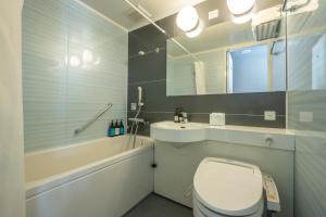 a bathroom with a toilet and a sink and a mirror at Prince Smart Inn Osaka Yodoyabashi in Osaka