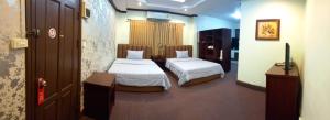 a hotel room with two beds in a room at Excellency Apartment in Vientiane