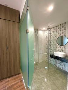 a bathroom with a glass shower and a sink at Homestay Vũ Miên, Tây Hồ, Ba Đình in Hanoi