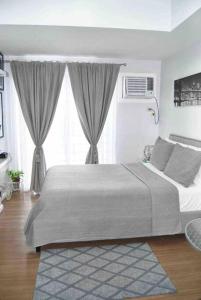a bedroom with a large bed in front of a window at New York Suite at The Loop at Limketkai in Cagayan de Oro