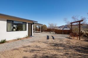 a house with a gravel driveway in front of it at Dt Jt Hot Tub Fire Pit Resort Feels in Joshua Tree