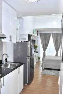 a kitchen with a refrigerator and a bed in a room at New York Suite at The Loop at Limketkai in Cagayan de Oro