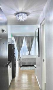 1 dormitorio con cama y lámpara de araña en New York Suite at The Loop at Limketkai, en Cagayan de Oro