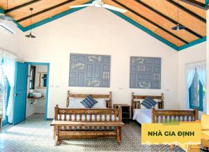a bedroom with two beds and two benches at Wonder Farm Ba Vi - Heritage Retreat in Hà Lộc