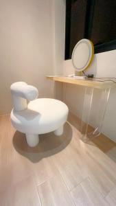 uma casa de banho com uma cadeira branca e um espelho. em 淳夏文旅民宿 第1310號 em Ch'ao-yang