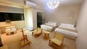 um quarto com 2 camas, uma mesa e cadeiras em 淳夏文旅民宿 第1310號 em Ch'ao-yang