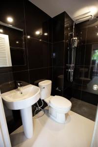 La salle de bains est pourvue de toilettes blanches et d'un lavabo. dans l'établissement VIP Great Hill, à Nai Yang Beach