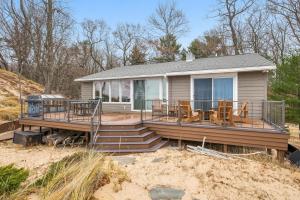 a house with a deck on the beach at Lakefront House with Private Beach by Michigan Waterfront Luxury Properties in Norton Shores