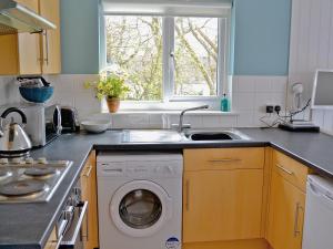 cocina con lavadora y ventana en Brook, en Wootton Bridge