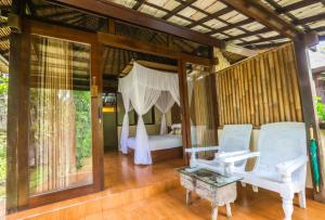 a bedroom with a bed and a chair and a table at Ubud Sari Health Resort in Ubud