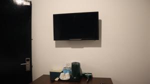 a flat screen tv hanging on a white wall at Room V at Kluang Parade Near Bus Stop Kluang in Kluang