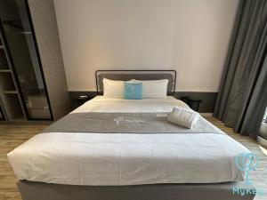 duże łóżko w sypialni z białą narzutą w obiekcie Millerz Square by Mykey Global w Kuala Lumpur